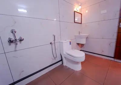 a bathroom with a toilet and a sink at Oasis Apartment with Pool in Vythiri in Vythiri