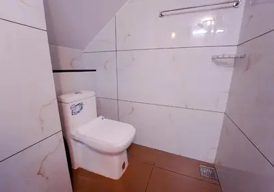 a white bathroom with a toilet and a shower at Oasis Apartment with Pool in Vythiri in Vythiri