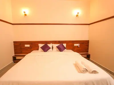 a bedroom with a white bed with two towels on it at Oasis Apartment with Pool in Vythiri in Vythiri