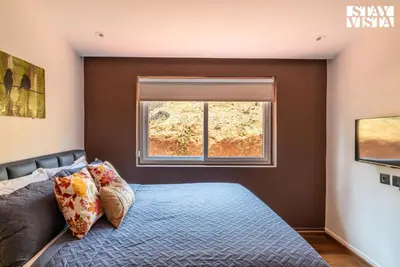 a bedroom with a bed and a window at StayVista at Valley Whispers with BBQ & Bonfire in Ooty