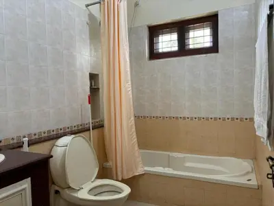 a bathroom with a toilet and a bath tub at Serene Nest Apartment-Kochi Airport in Nedumbassery