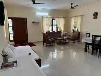 a living room with a couch and a table and chairs at Serene Nest Apartment-Kochi Airport in Nedumbassery