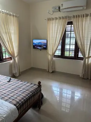 a bedroom with a bed and a flat screen tv at Serene Nest Apartment-Kochi Airport in Nedumbassery