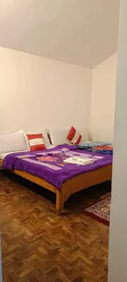 a bedroom with a large bed with purple sheets at Vi stays in Ooty