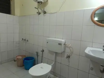 a bathroom with a toilet and a sink at Vi stays in Ooty