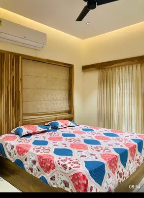 a bedroom with a bed with a red and blue quilt at LINE Villas in Kodungallūr