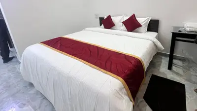 a bedroom with a large bed with red pillows at Portico Resorts in Pandalūr