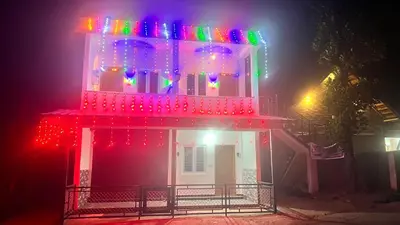 a house with christmas lights on top of it at Portico Resorts in Pandalūr