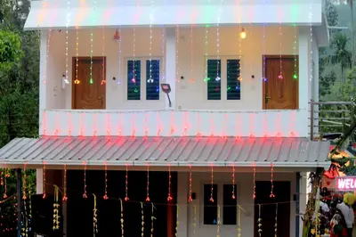 a house decorated with christmas lights and garland at Portico Resorts in Pandalūr