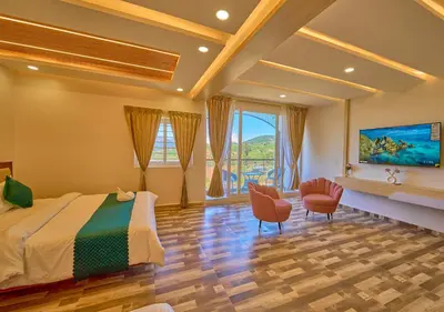a hotel room with a bed and two chairs at Vihani's Western Clouds Ooty by VOYE HOMES - Peaceful Getaway Near Avalanche Emerald Lake in Ooty