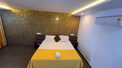 a hotel room with a bed with a yellow blanket at 3 Empire One Bedroom with Common Pool in Wayanad