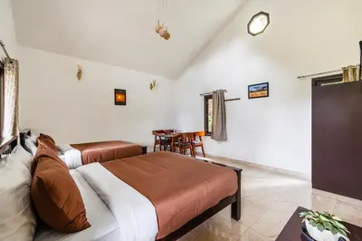 a bedroom with two beds and a table and a clock at Interlaken in Yedapalli