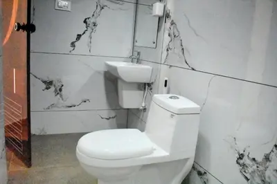 a bathroom with a white toilet and a sink at Green Heaven Kuruva Wayanad in Chekadi