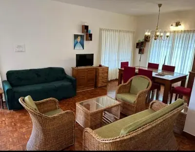 a living room with a couch and chairs and a table at Ivy Cottage Kodaikanal in Kodaikānāl
