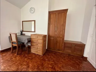 a room with a table and a cabinet and a mirror at Ivy Cottage Kodaikanal in Kodaikānāl