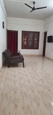 a living room with a couch and a ceiling fan at Holiday Apartments & Homestay in Sultan Bathery