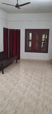 a living room with a couch and two windows at Holiday Apartments & Homestay in Sultan Bathery