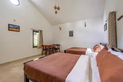 a bedroom with two beds and a table in it at Interlaken - 4 BR VIlla in Yedapalli
