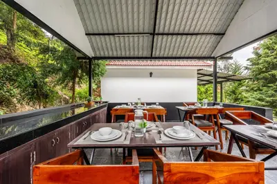an outdoor dining area with tables and chairs at Interlaken - 4 BR VIlla in Yedapalli