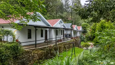 a row of white cottages in a forest at Interlaken - 4 BR VIlla in Yedapalli
