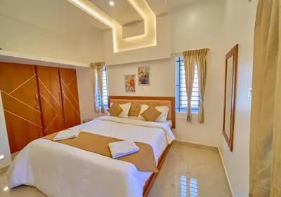 a bedroom with a large bed with white sheets at Central Homestay Ooty by VOYE HOMES Family-Friendly Budget Stay with Valley And Mountain Views in Ooty