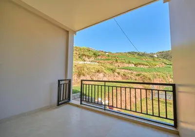 a room with a balcony with a view at Central Homestay Ooty by VOYE HOMES Family-Friendly Budget Stay with Valley And Mountain Views in Ooty