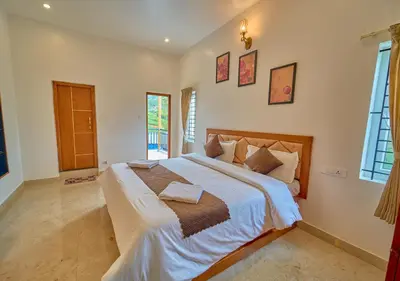a bedroom with a large bed in a room at Central Homestay Ooty by VOYE HOMES Family-Friendly Budget Stay with Valley And Mountain Views in Ooty