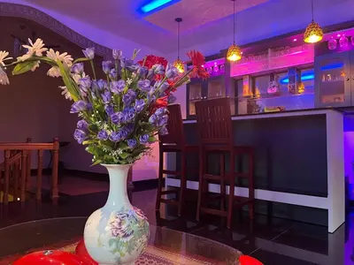 a vase with flowers on a table in a bar at 