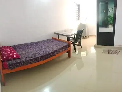 a bedroom with a bed and a desk and a table at Aswathy Bhavan in Palakkad