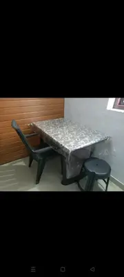a table and a bench with a table and a chair at Aswathy Bhavan in Palakkad