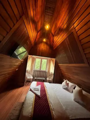 a bedroom with a bed in a wooden room at River Valley Huts, Wayanad in Panamaram