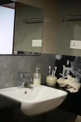 a bathroom with a white sink and a mirror at Dreams Valley in Kadavoor