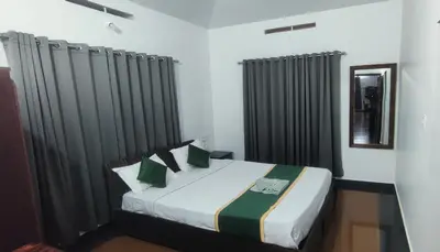 a bedroom with a large bed with black curtains at Stone Villa in Blooms Green Farm in Wayanad