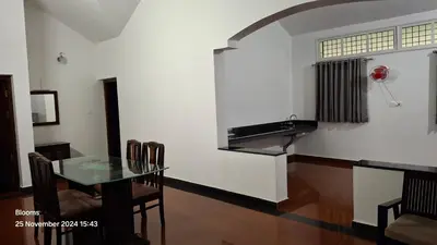 a dining room with a glass table and a sink at Stone Villa in Blooms Green Farm in Wayanad