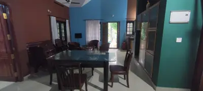 a dining room with a black table and chairs at Blooms Aquatica in Kenichira