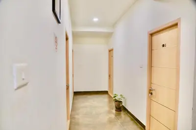 a hallway with a door and a potted plant at Virksham Hotel in Coimbatore