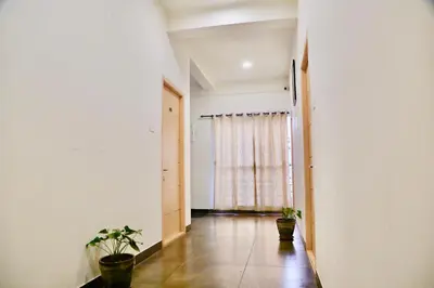 a hallway with two potted plants and a window at Virksham Hotel in Coimbatore