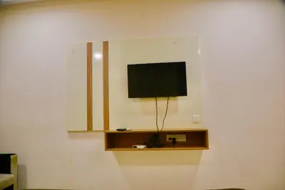 a flat screen tv on a wall in a room at Virksham Hotel in Coimbatore
