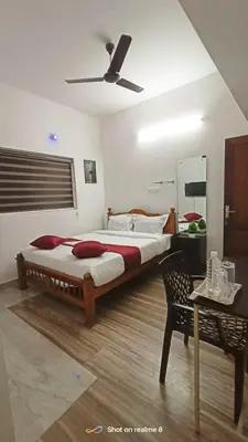 a bedroom with a large bed and a ceiling fan at calicut residency in Kozhikode