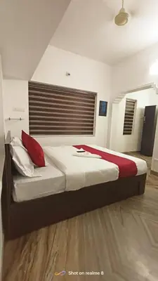 a bedroom with a large bed with red pillows at calicut residency in Kozhikode