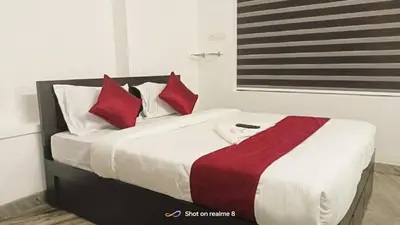 a bedroom with a bed with red and white pillows at calicut residency in Kozhikode