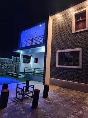 a chair in front of a building at night at Jazz&Hill in Kodaikānāl