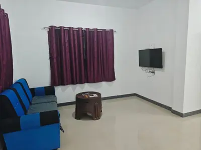 a living room with a couch and a tv at Jazz&Hill in Kodaikānāl