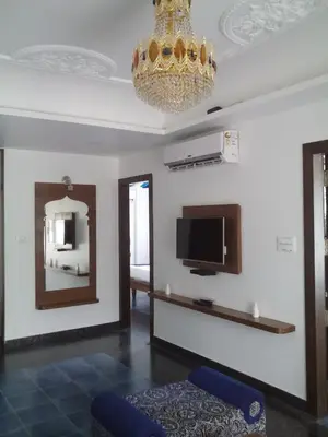 a living room with a television and a chandelier at Sepoy Grande Mysore in Mysore