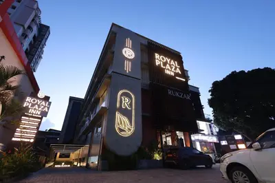 a building with a clock on the side of it at Royal Plaza Inn by RAK Rooms, Calicut in Kozhikode