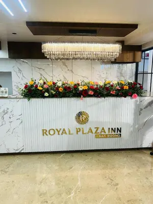 a sign for a royal plaza inn with flowers on it at Royal Plaza Inn by RAK Rooms, Calicut in Kozhikode