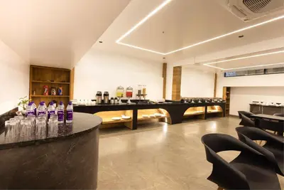 a bar in a room with bottles of wine at Royal Plaza Inn by RAK Rooms, Calicut in Kozhikode