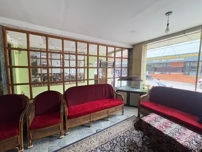 a waiting room with two red chairs and a window at Hotel SilverLine Regency Munnar in Munnar