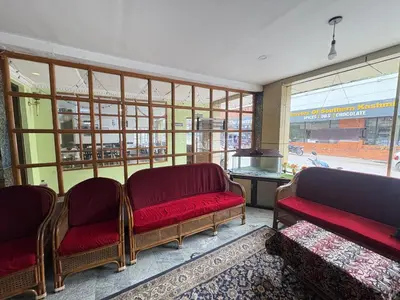 a waiting room with two red benches and a window at Hotel SilverLine Regency Munnar in Munnar