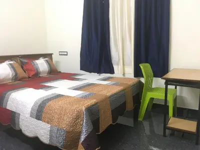 a bedroom with a bed and a desk and a table at Peaceful perch in Kozhikode